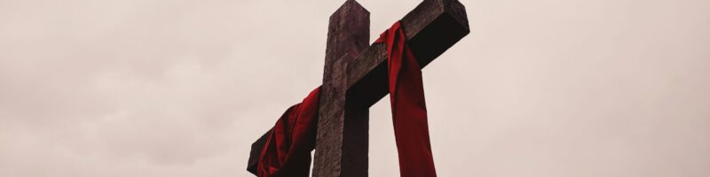 low angle view of cross with red garment