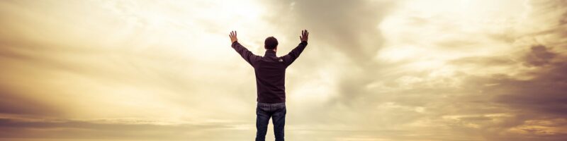 man standing under orange sky