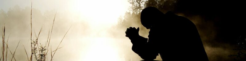 silhouette of kneeling man