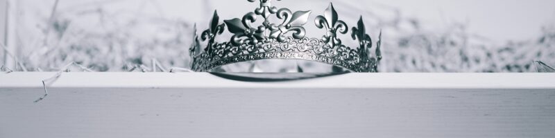 silver-colored crown on top of white wood