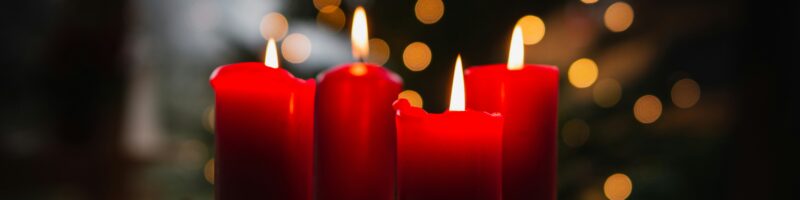 shallow focus photo of four red lighted candles