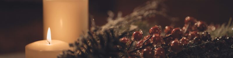white pillar candle on brown wooden table