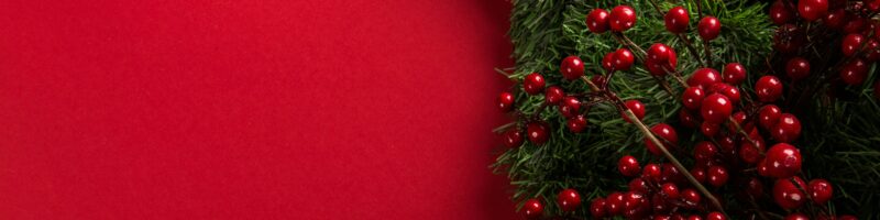 a close up of a christmas wreath on a red background