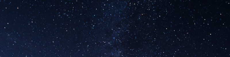 silhouette of man looking at milky way