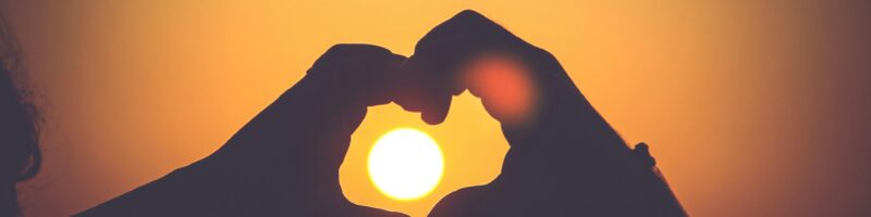 silhouette of person's hands forming heart